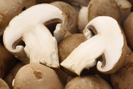 一束新鲜香菇和一个切开的蘑菇的背景图片
