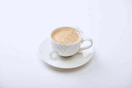 在白色背景的碟子上的杯子里有泡沫的美味咖啡图片