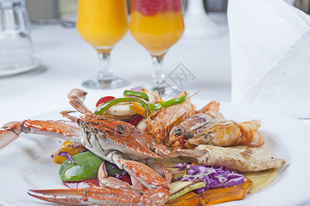 游泳蟹和虎虾的新鲜海餐沙拉在白色盘子上图片