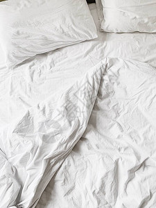 平坦的躺下白麻布毯子和两个枕头图片