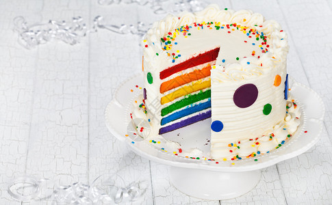 多彩的虹层生日蛋糕装饰用圆点喷洒图片