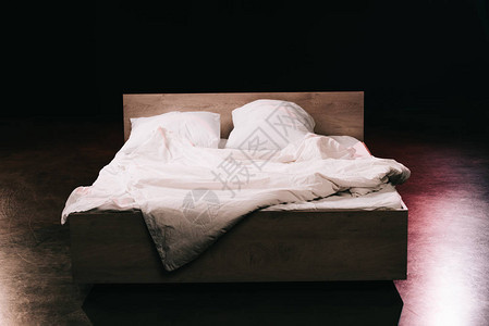 黑色卧室白色干净床单上的柔软枕头图片