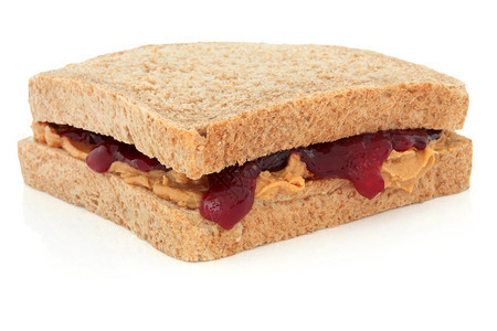 花生酱和草莓果酱三明治在棕色面包上图片