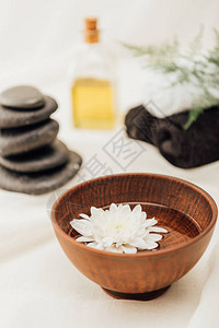 白色背景木碗中水疗配件和菊花的选择布置图片