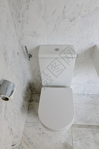 白色大理石瓷砖浴室中的白色马桶图片