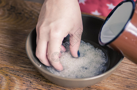厨房里的女人用水洗米图片
