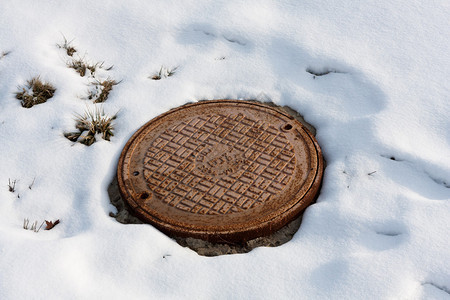 雪下生锈的井盖图片