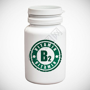 白色背景中含有维生素B2的一瓶药丸图片