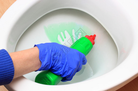 使用洗涤剂家庭清洁和家务劳动概念的蓝手套清扫厕所碗中的图片