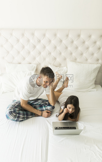 父亲和女儿一起躺在床上图片