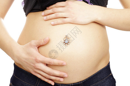 在肚脐穿孔的年轻孕妇的腹部图片