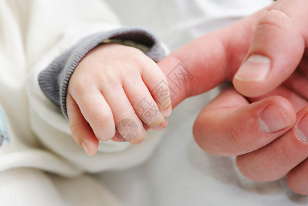 新生婴儿握着父亲的手指图片