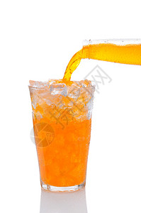 将一瓶橙色苏打汽水倒入冰玻璃背景图片