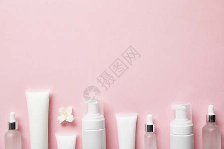 粉红色上的化妆玻璃瓶奶油管化妆品喷图片