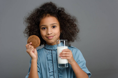 带着牛奶和饼干杯子的快乐的非裔美国儿童在图片