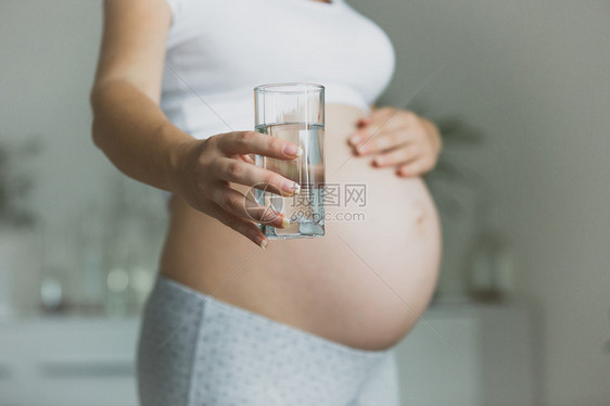 孕妇拿着杯水的近照片妇图片