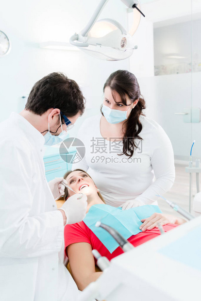 牙科医生和护理人员在对孕妇进行外科手术时为图片