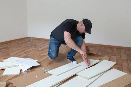 男人在新房子里穿着休闲组装家具木匠在家修图片