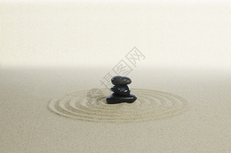 沙子背景上的三块黑石图片
