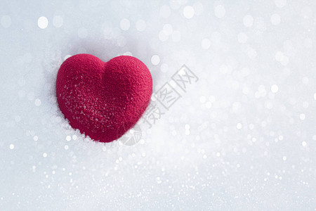 在波光粼的雪中的红心情人节的概念爱情幸福和奉献的象征顶视图片