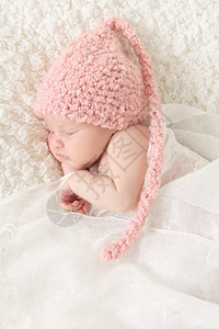 新生女婴裹着老旧的蕾丝戴着粉图片