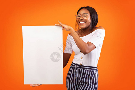 非洲裔美国女孩在工作室的橙色背景上站立的文字图片