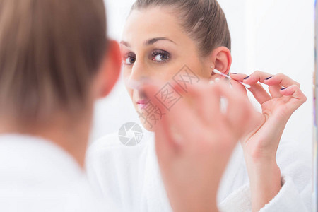 浴室里的女人用棉签擦耳朵背景图片