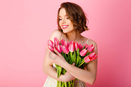 美丽的女人的肖像春月郁金香花束在粉图片