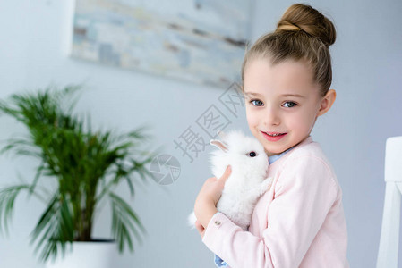 拥抱白色兔子的小女孩图片