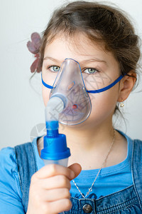 有哮喘吸入器的女孩有哮喘问题的女孩用她脸上的面具吸入呼吸系统疾图片
