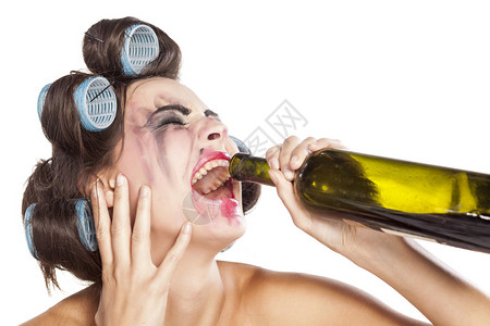 分手.哭着喝瓶酒喝葡萄酒的醉年轻女背景