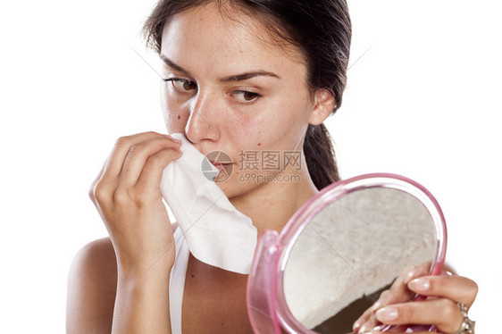 年轻女子拿着镜子用湿组织除掉化妆品图片