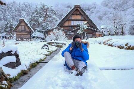 摄影师在冬季下雪时在白川乡地区拍照图片