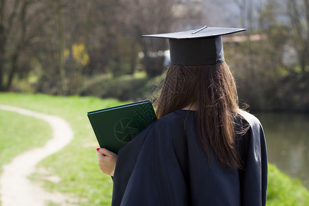 相当聪明的大学生毕业后的女孩完成仪式穿着长袍和灰泥板图片