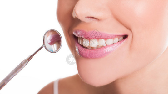 在牙齿和口腔卫生和护理概念中使用牙镜展示她健康洁白牙齿图片