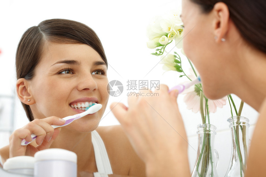 美的女早上在镜子前刷牙的画面图片