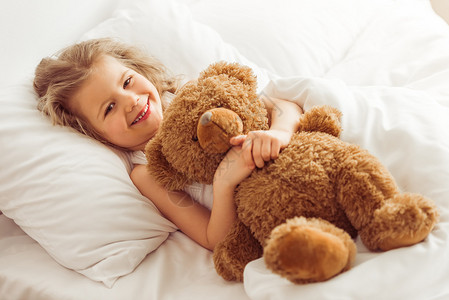 可爱的小女孩抱着一只泰迪熊图片