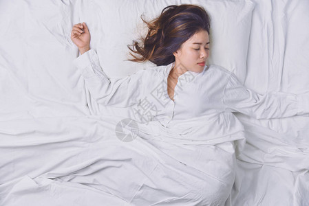 睡在床上的少妇躺在床上睡得很好的年轻女子的顶视图睡觉放松图片