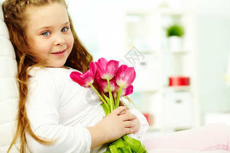 带着郁金香花束的快乐女孩的肖图片