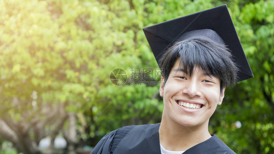 男生学在毕业礼服和帽子上微图片