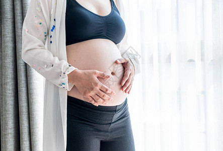 带手的怀孕妇女的腰部用旧式过滤风格图片