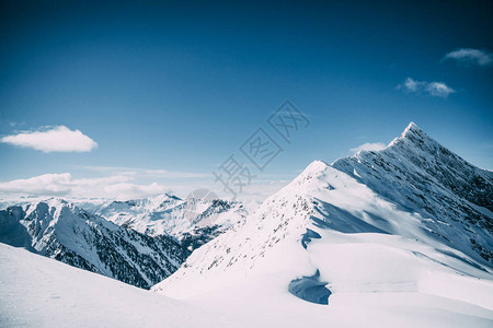 在阳光明媚的日落时美丽的雪盖高山峰奥斯特里图片