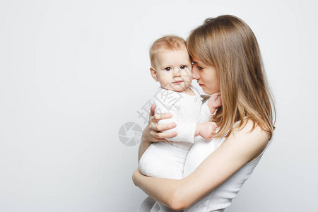 怀着女婴站在白色背景的白背面的年轻美背景图片