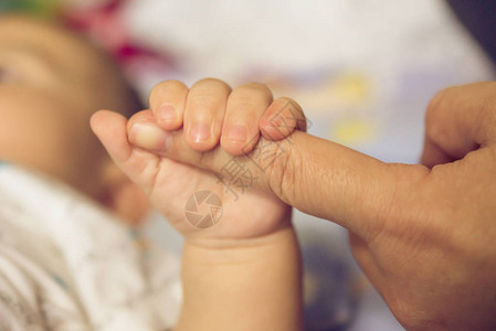 母亲的手握着婴儿的手图片