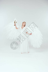 穿着天使装扮的漂亮女人翅膀握着蜡烛白图片