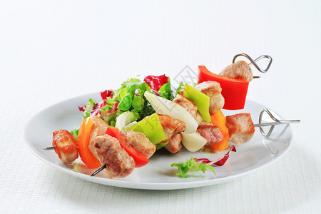 鸡肉和猪肉串配蔬菜沙拉图片