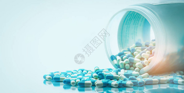 蓝色和白色胶囊药丸从白色塑料瓶容器中溢出全球医疗保健概念抗生素耐药抗菌胶囊图片