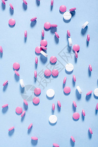 蓝色背景上的粉红色和白色药丸图片