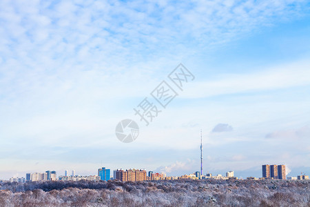 城市房屋和电视塔上满天白云的蓝色天空背景图片