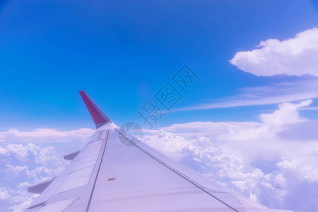 飞机翼在白云上空飞行蓝天通过飞机窗口看图片
